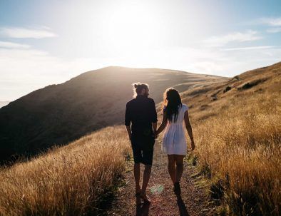 pareja paseando por un camino rural al atardecer