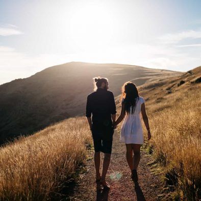 pareja paseando por un camino rural al atardecer