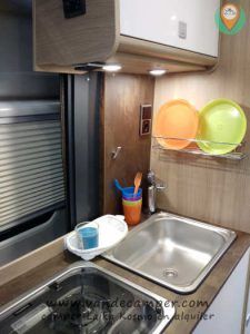 cocina con platos y vasos de colores en camper