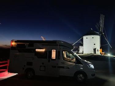 vista nocturna autocaravana de alquiler de VandeCamper en los molinos de Consuegra