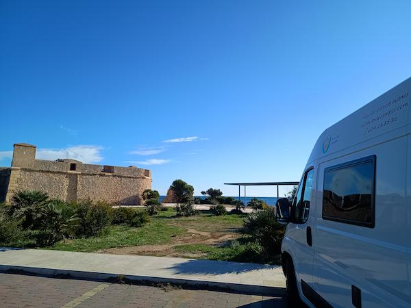 camper de alquiler en cunit de VandeCamper aparcada frente castillo en la costa