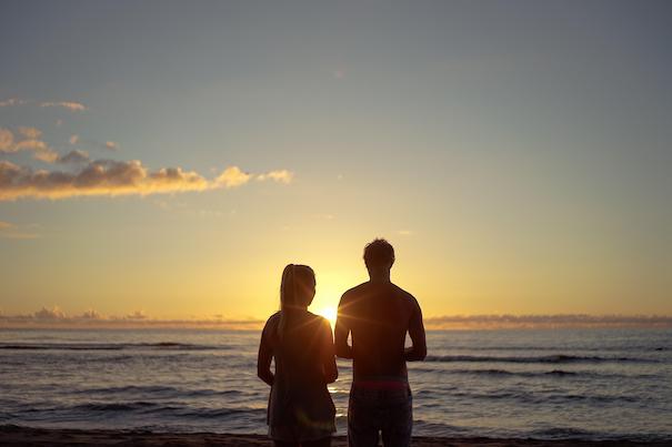 pareja en la playa observando el amanecer
