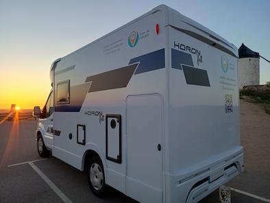 autocaravana de alquiler de VandeCamper aparcada frente a una puesta de sol en los molinos de Consuegra