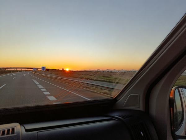 amanecer conduciendo visto desde la cabina de una camper de alquiler